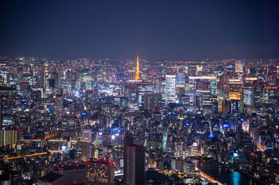 High angle view of illuminated cityscape against clear sky at night