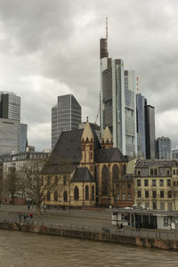 Buildings in city against cloudy sky