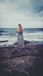 Rear view of woman looking at sea against sky