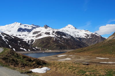 Scenic view of snowcapped mountains against blue sky