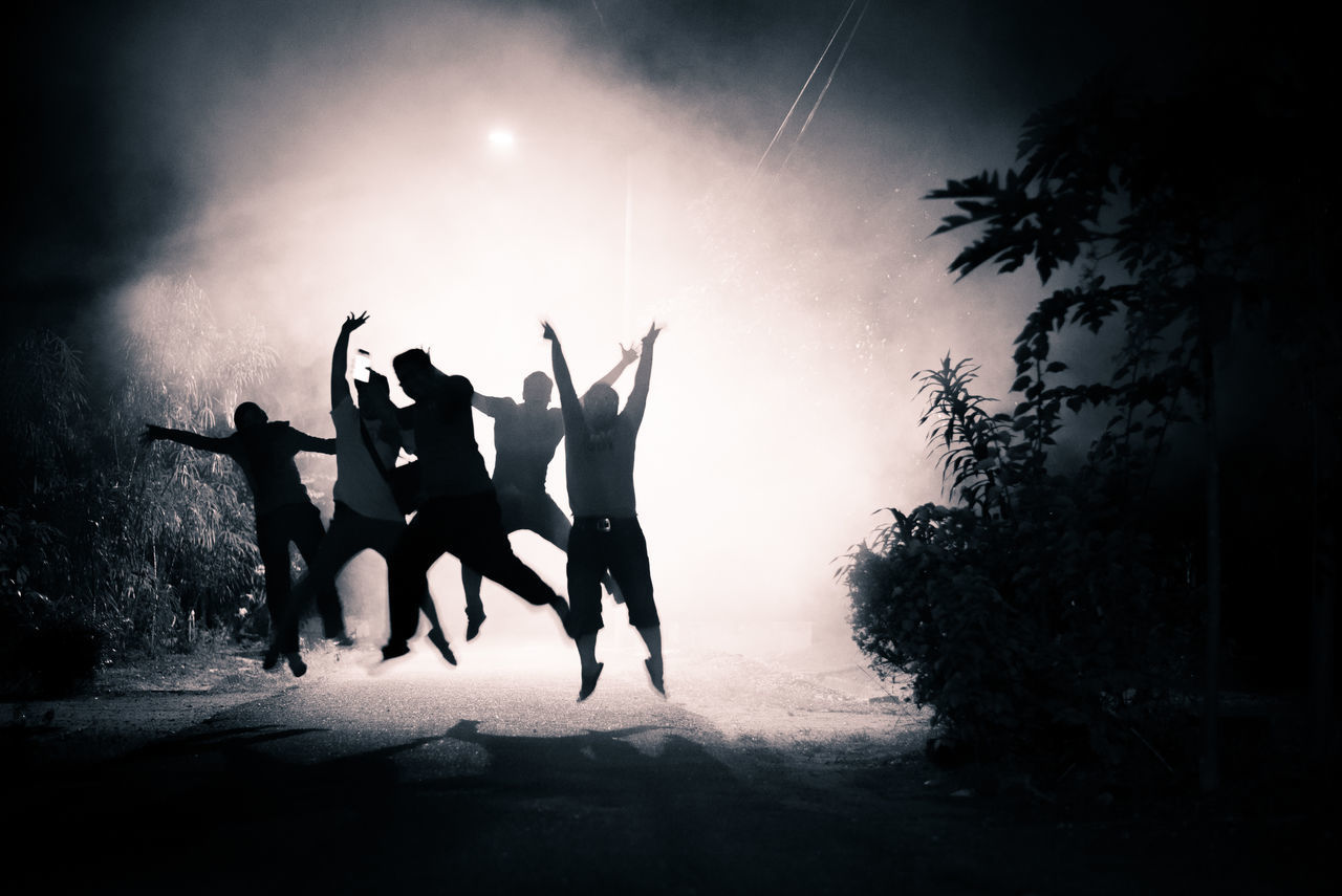 People jumping on road at night