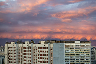 Buildings in city against sky during sunset