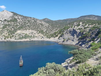 Scenic view of sea and mountains against blue sky