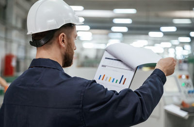 Rear view of man standing in factory