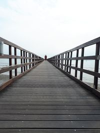 Footbridge over pier against sky