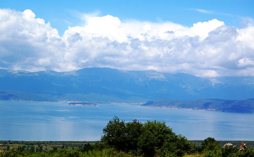 Scenic view of sea and mountains against sky