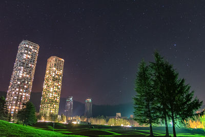 Low angle view of illuminated buildings against sky at night