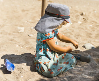 Cute girl playing with sand at beach