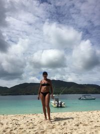 Full length of young woman standing on beach