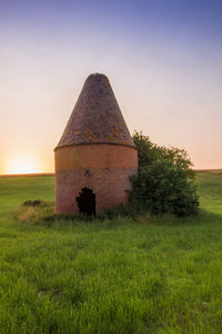 Built structure on field against sky