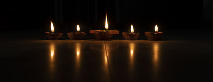 Close-up of illuminated candles on table