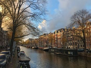 Canal amidst buildings in city against sky