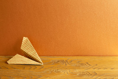 Close-up of paper on table against orange background