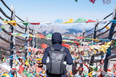 Rear view of people standing against sky