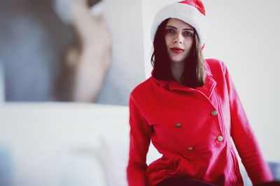 Portrait of young woman wearing santa hat at home