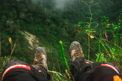 Low section of person sitting on mountain