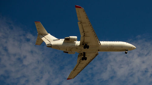 Low angle view of airplane flying against sky