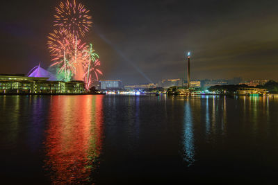 Firework display over illuminated city at night