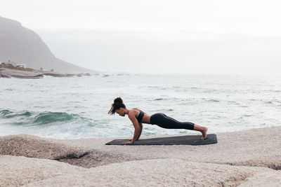 Rear view of woman sitting on beach