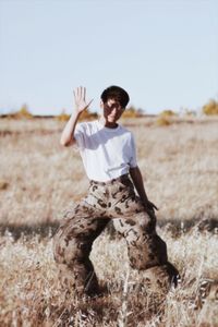 Full length of boy standing on field against clear sky