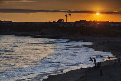 High angle view of people at beach during sunset
