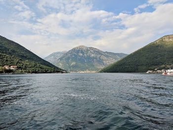 Scenic view of lake by mountains against sky