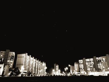 Illuminated buildings against sky at night