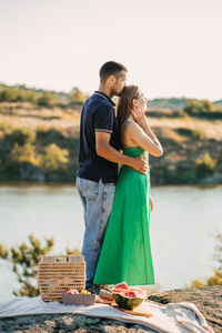 Happy loving couple kissing and having date outdoors. young couple on summer picnic with watermelon