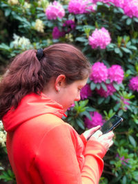 Close-up of woman holding red mobile phone