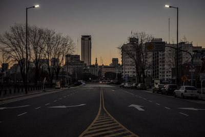 Empty road in city against clear sky