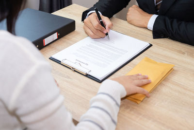 High angle view of people sitting on table