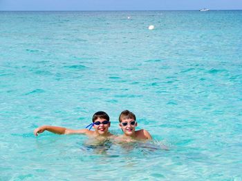 Portrait of friends swimming in sea