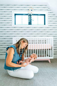 A mother holding her newborn baby in a modern nursery