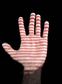 Close-up of human hand against black background