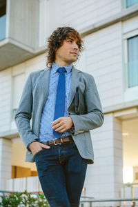 Low angle view of young man standing against house