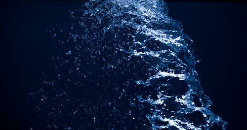 Close-up of water flowing over black background