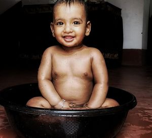 Portrait of shirtless boy in bathroom