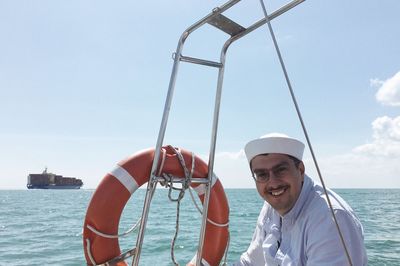 Portrait of smiling man in sea against sky