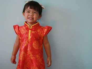 Cute girl standing against red background