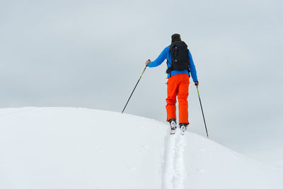 Rear view of person skiing on snow against mountain