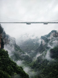 Low angle view of bridge over mountains against sky