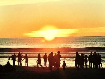 People on beach at sunset