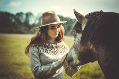 Young woman with horse on field