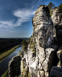 Rock formation by sea against sky
