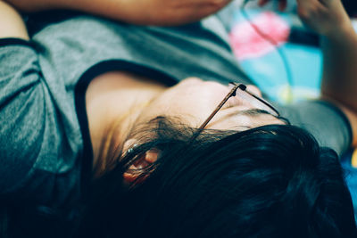 Close-up of woman wearing eyeglasses sleeping at home