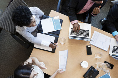 Overhead view of business people at desk during meeting