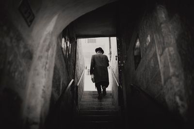 Rear view of man walking on stairs