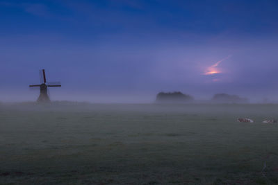 Scenic view of land against sky during foggy weather