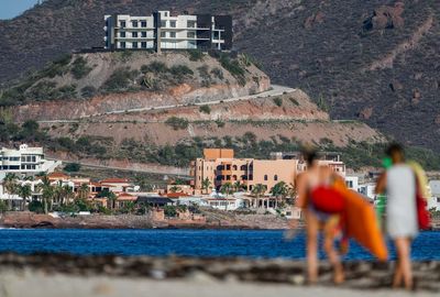 People on beach by buildings in city