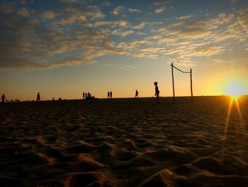 Silhouette man on beach against sky during sunset